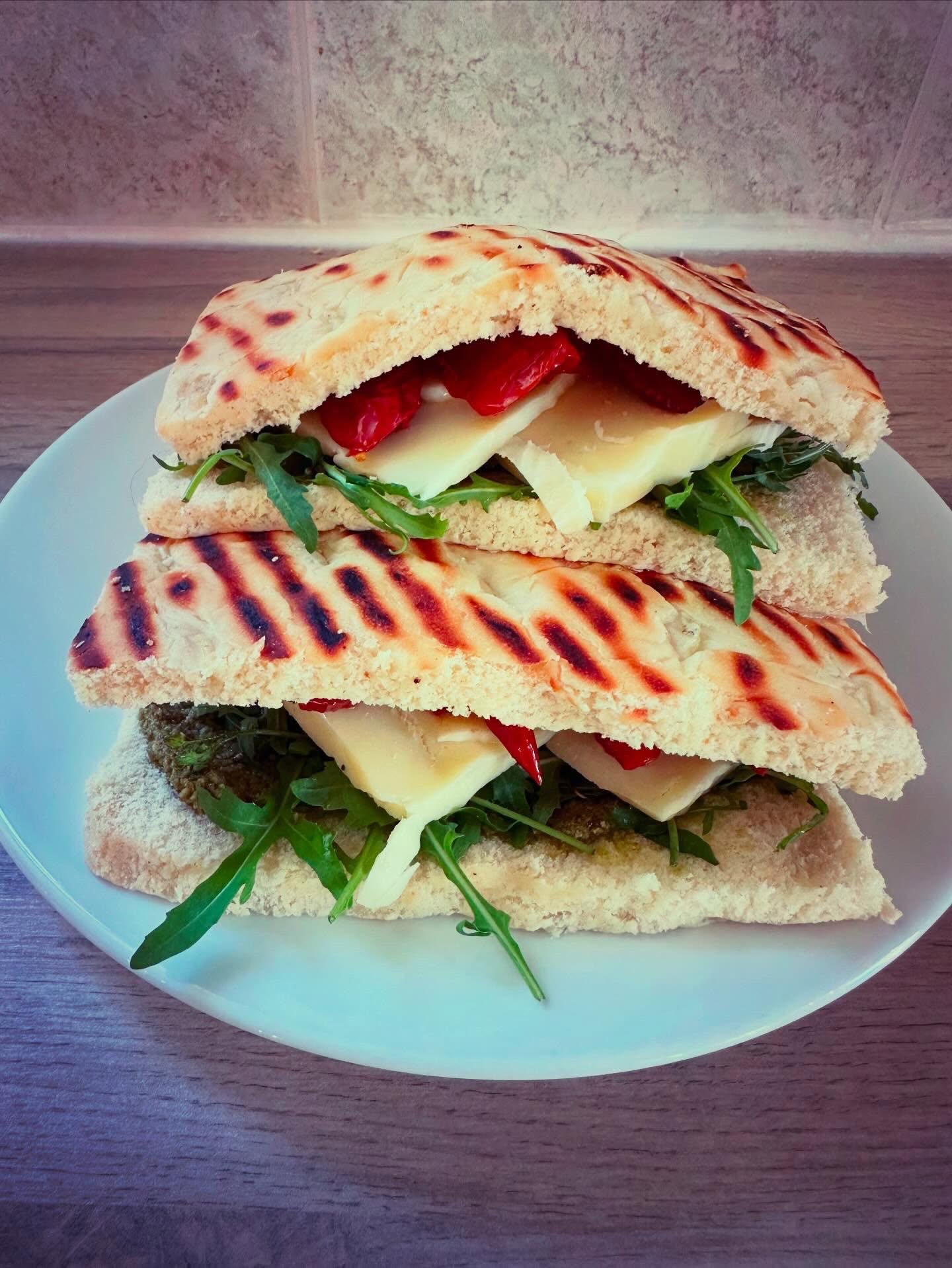 Stacked toasted sandwiches with rocket, cheese, and roasted peppers